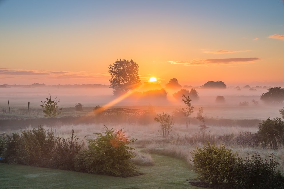 A misty English countryside sunrise in September