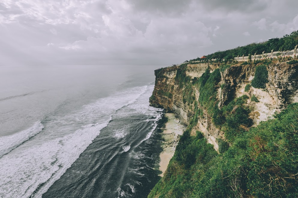 This is a huge cliff in Uluwatu, Bali, you can walk on a path, close to the edge, that brings you to a beautiful temple, Uluwatu Temple. The weather in Bali changes a lot, i got lucky to find this magical atmosphere with this soft light right on the rocks.